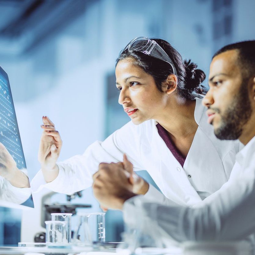 Male and a female scientist analyzing data on a computer.
